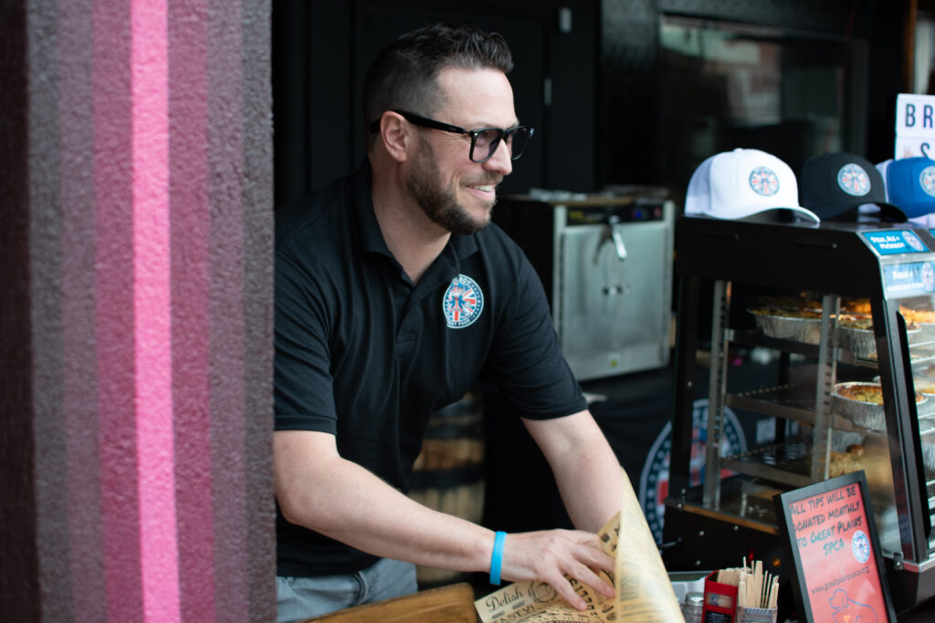 Owner of Brit Boy Street Food, Chris Thomas, proudly serving his customers outside a brewery pop up.